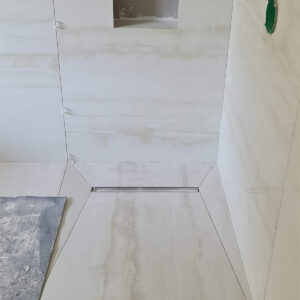 Walk-in shower tiling installation during the full Weybridge house refurbishment
