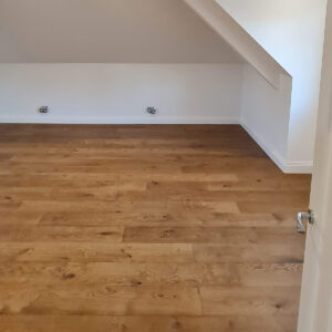 Spacious loft room with oak flooring completed during the Weybridge loft conversion