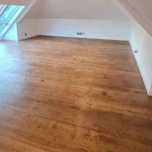 Completed loft bedroom with oak flooring by Croydon-based construction company Art & Build Ltd