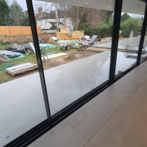 Open-plan living room with sliding doors and garden view in the Weybridge extension
