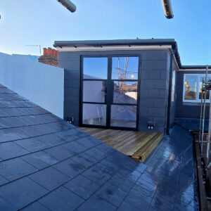 Completed L-shaped loft conversion with slate roof, French doors and roof terrace in Croydon, by experienced builders based in Croydon