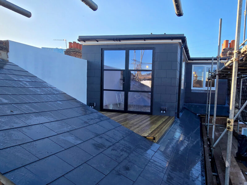 Completed L-shaped loft conversion with slate roof, French doors and roof terrace in Croydon, by experienced builders based in Croydon