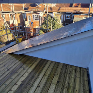 Finished timber roof terrace with rendered privacy wall and rooftop view, by Croydon-based builders Art & Build Ltd