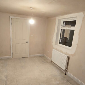 Plastered loft master bedroom with radiator, window and recessed ceiling lights, by Art & Build Ltd, a Croydon-based construction company