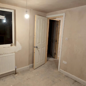Newly plastered loft bedroom with radiator, windows and recessed lighting, by Croydon loft conversion builders Art & Build Ltd