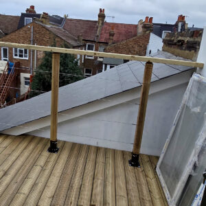Completed rear dormer roof terrace with timber decking and glass balustrade, by experienced builders based in Croydon