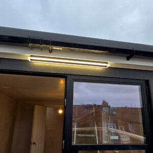 Finished slate-clad rear dormer with black-framed glazed doors and exterior lighting, by Art & Build Ltd, Croydon builders serving South London
