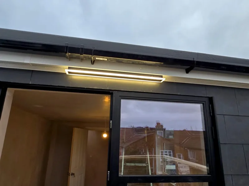 Exterior loft conversion detail with lighting and sliding doors opening onto roof terrace on Byegrove Road