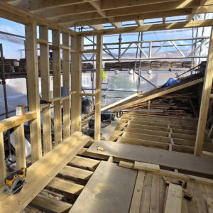 L-shaped loft conversion with new timber walls, floor joists and dormer framing, by experienced builders based in Croydon