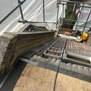 Prepared roof opening with exposed brickwork and temporary deck during construction, by Art & Build Ltd, a Croydon-based construction company