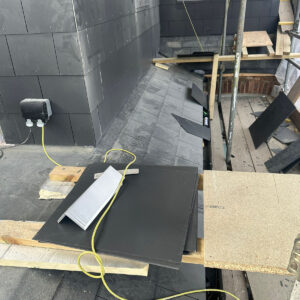 Detailed view of grey slate cladding fitted around a dormer wall, by the Croydon-based team at Art & Build Ltd