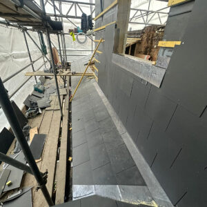 Grey slate cladding fitted around a framed roof opening, by experienced builders based in Croydon