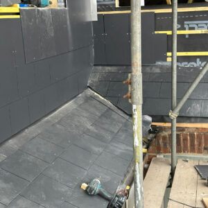 Grey slate cladding installed on the walls surrounding a roof terrace, by Croydon-based builders Art & Build Ltd