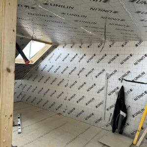 Pitched loft ceiling lined with reflective insulation around a roof window, by Croydon-based builders Art & Build Ltd