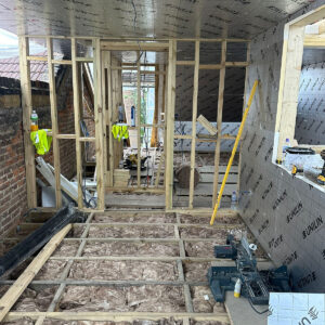 Insulation fitted between loft floor joists beside new timber wall framing, by Art & Build Ltd, a Croydon-based construction company