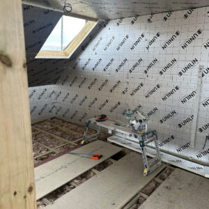 Reflective insulation fitted across a pitched loft roof with roof window, by experienced builders based in Croydon