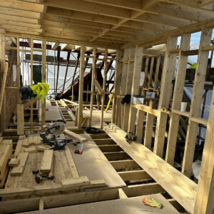 Interior of an L-shaped loft conversion with timber floor and wall framing, by Art & Build Ltd, Croydon builders serving South London