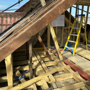 Existing pitched roof rafters beside new timber framing for a loft conversion, by Art & Build Ltd, a Croydon-based construction company