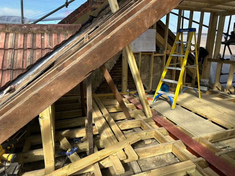 Existing pitched roof rafters beside new timber framing for a loft conversion, by Art & Build Ltd, a Croydon-based construction company