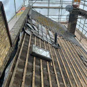 Existing roof framing, battens and rooflights exposed during preparation for a loft conversion