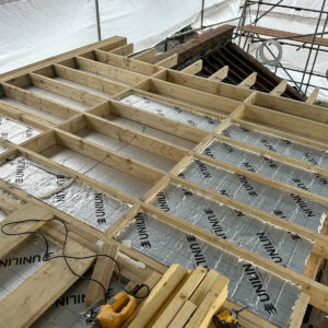 Rigid insulation installed between timber joists in a flat dormer roof in Southwark