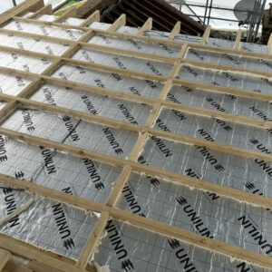 Insulation boards installed between timber joists in the flat roof of a dormer conversion