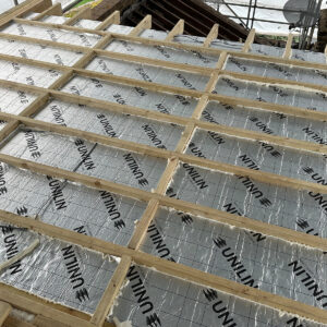 Insulation boards installed between timber joists in the flat roof of a dormer conversion