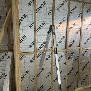 Foil-backed PIR insulation fitted between timber wall studs in a Southwark loft conversion
