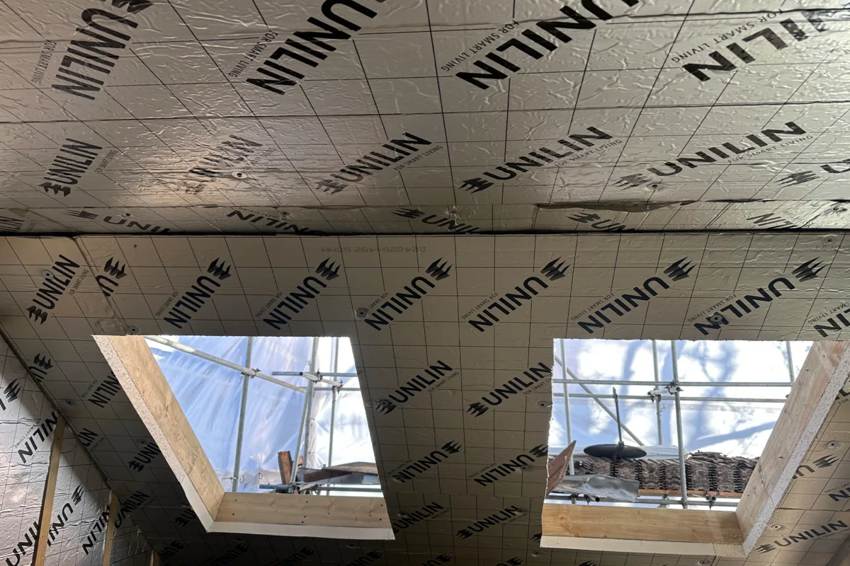 Foil-backed roof insulation fitted around two VELUX windows in a Southwark loft conversion