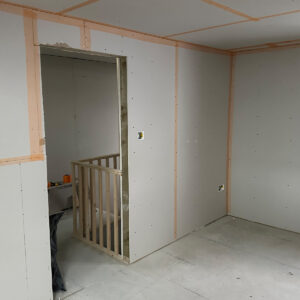 New loft room with plasterboard installed around the doorway and staircase opening in Southwark