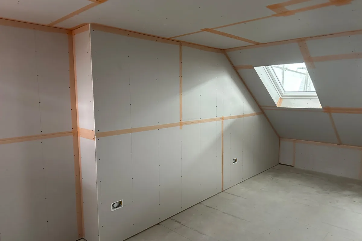 Plasterboarded loft bedroom with sloping ceiling and rooflight ready for plastering