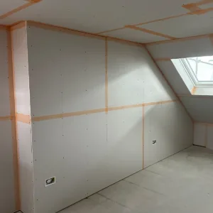 Plasterboarded loft bedroom with sloping ceiling and rooflight ready for plastering
