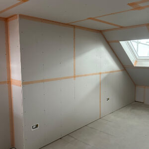 Plasterboarded loft bedroom with sloping ceiling and rooflight ready for plastering