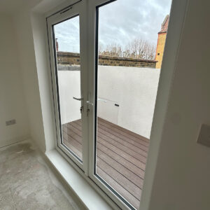 New loft bedroom with glazed doors providing access to the roof terrace in Southwark SE17