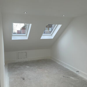 Bright loft bedroom with two VELUX roof windows and recessed ceiling lights in Southwark