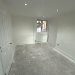 Completed white loft bedroom with built-in storage and recessed lighting ready for final flooring in Southwark