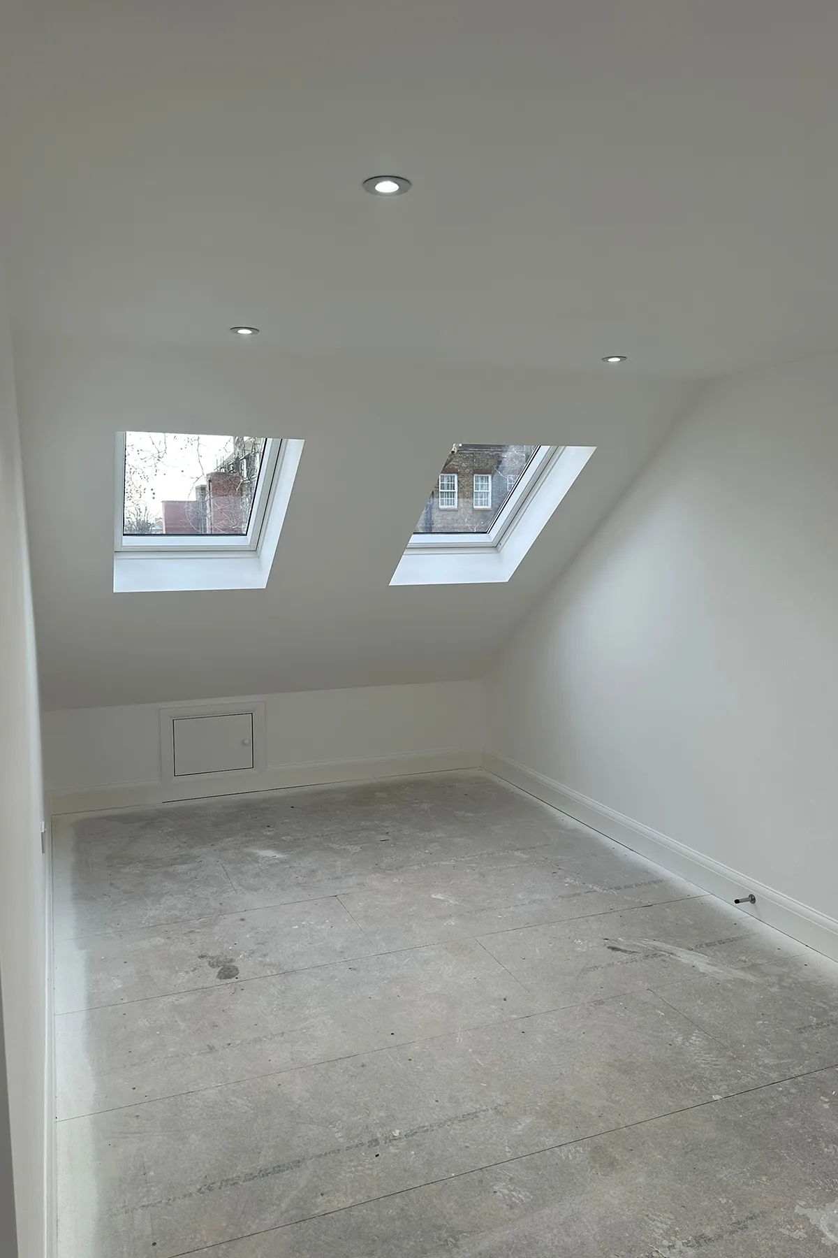 Loft bedroom with rooflights and sloped ceiling after loft conversion in Croydon