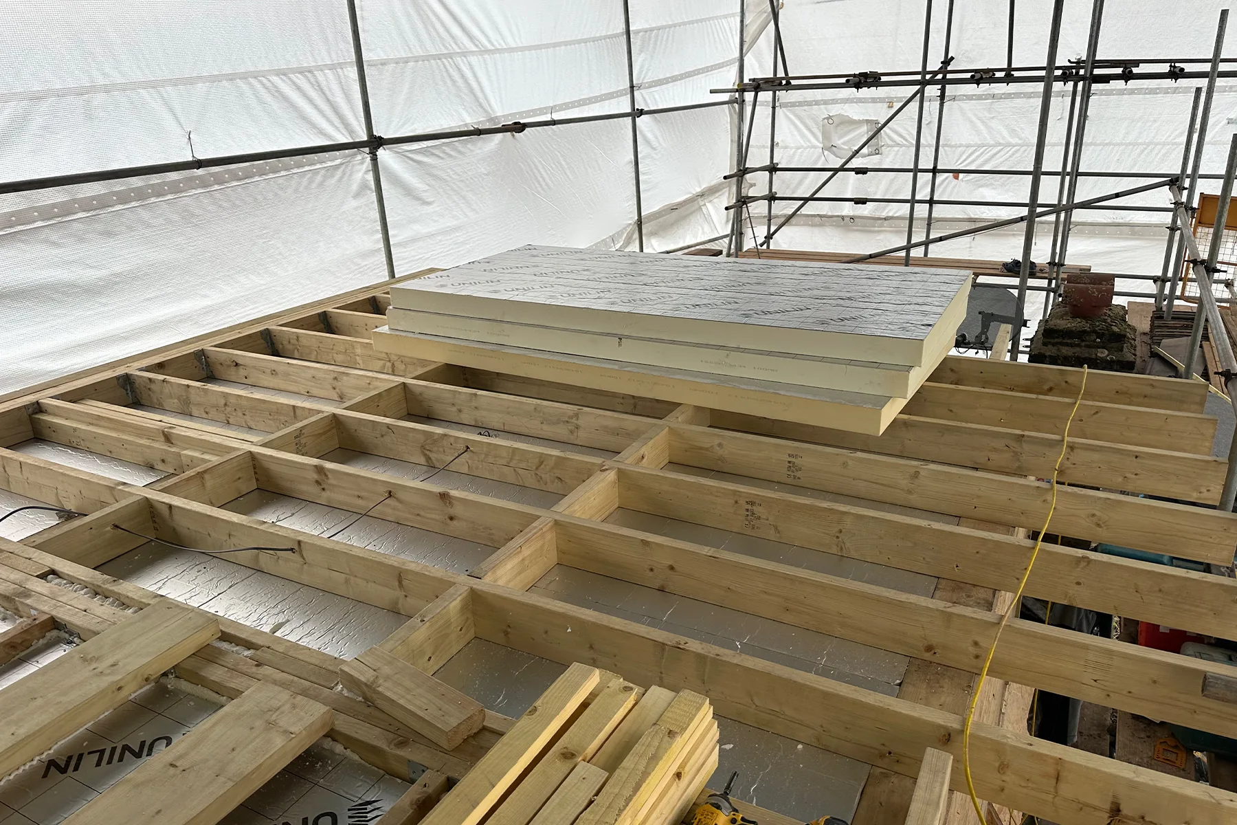 Roof insulation being installed within the dormer structure during loft conversion in Croydon