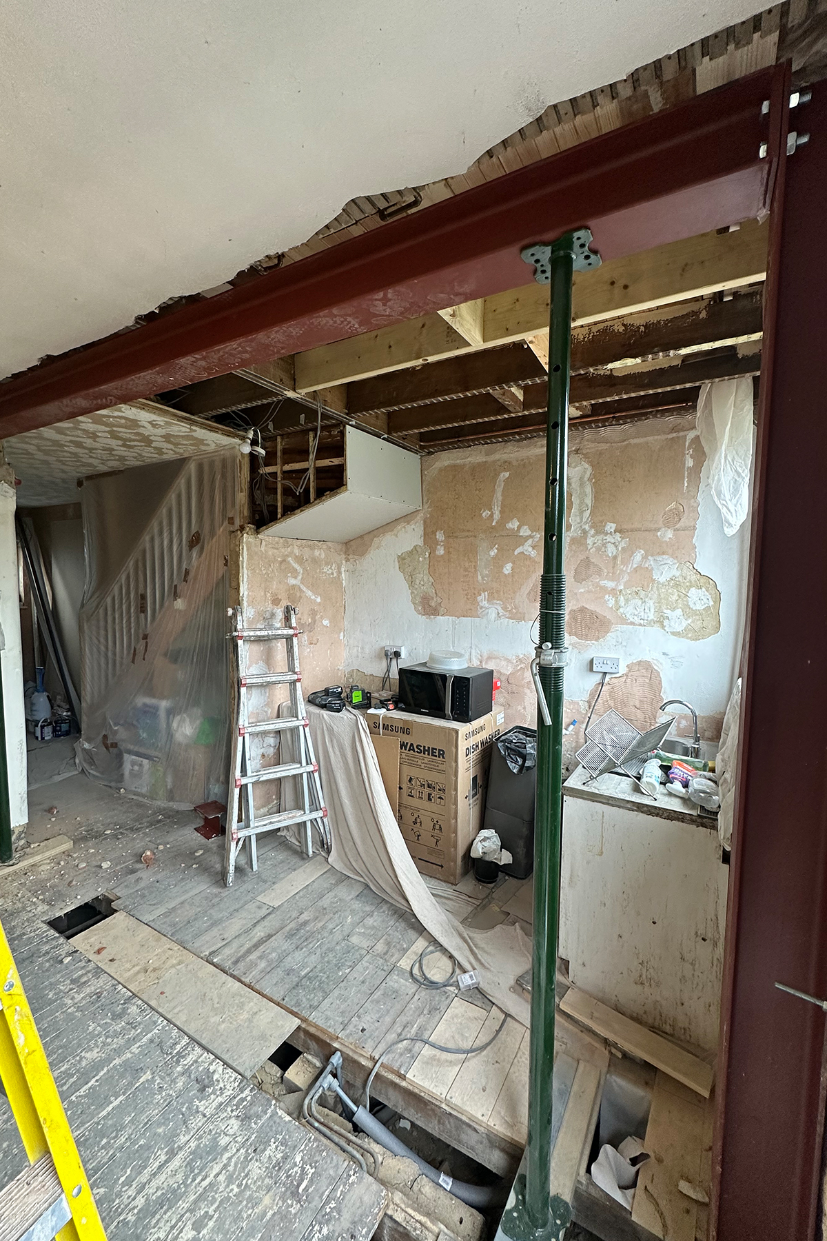 Steel beam installed with temporary structural supports during kitchen opening works in Croydon