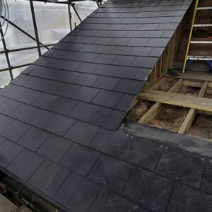 New slate-covered rear dormer roof beside exposed timber roof framing, by Croydon loft conversion builders Art & Build Ltd