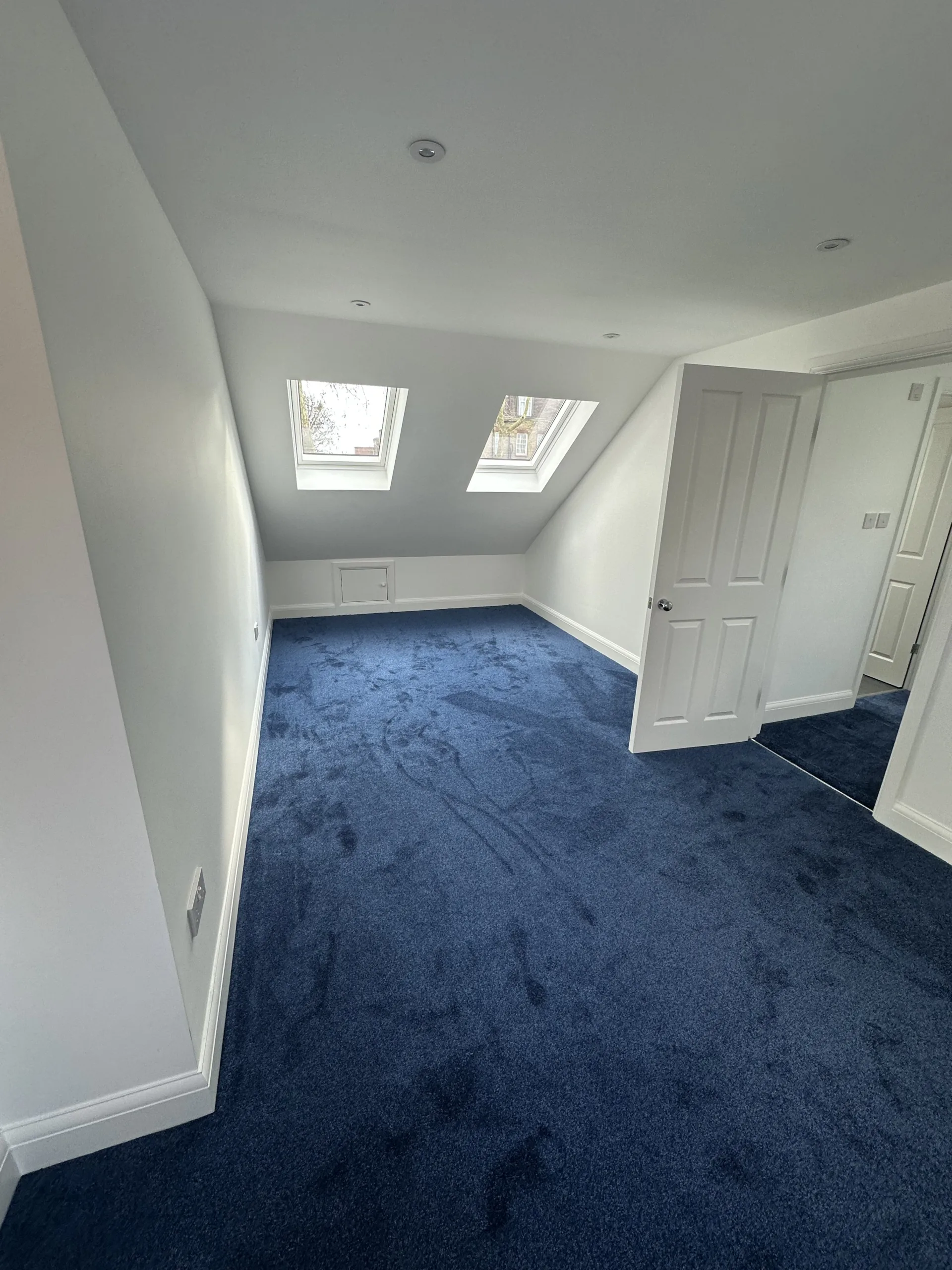 Completed loft conversion in Croydon by Art & Build Ltd with bright modern bedroom and roof windows
