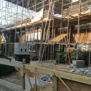 Scaffolding and structural steel framework surrounding the Weybridge house extension