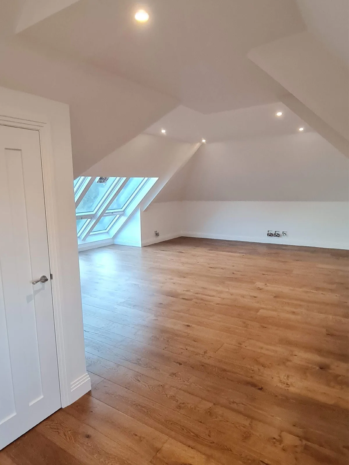 Finished loft conversion with Velux roof windows and oak flooring by Art & Build Ltd
