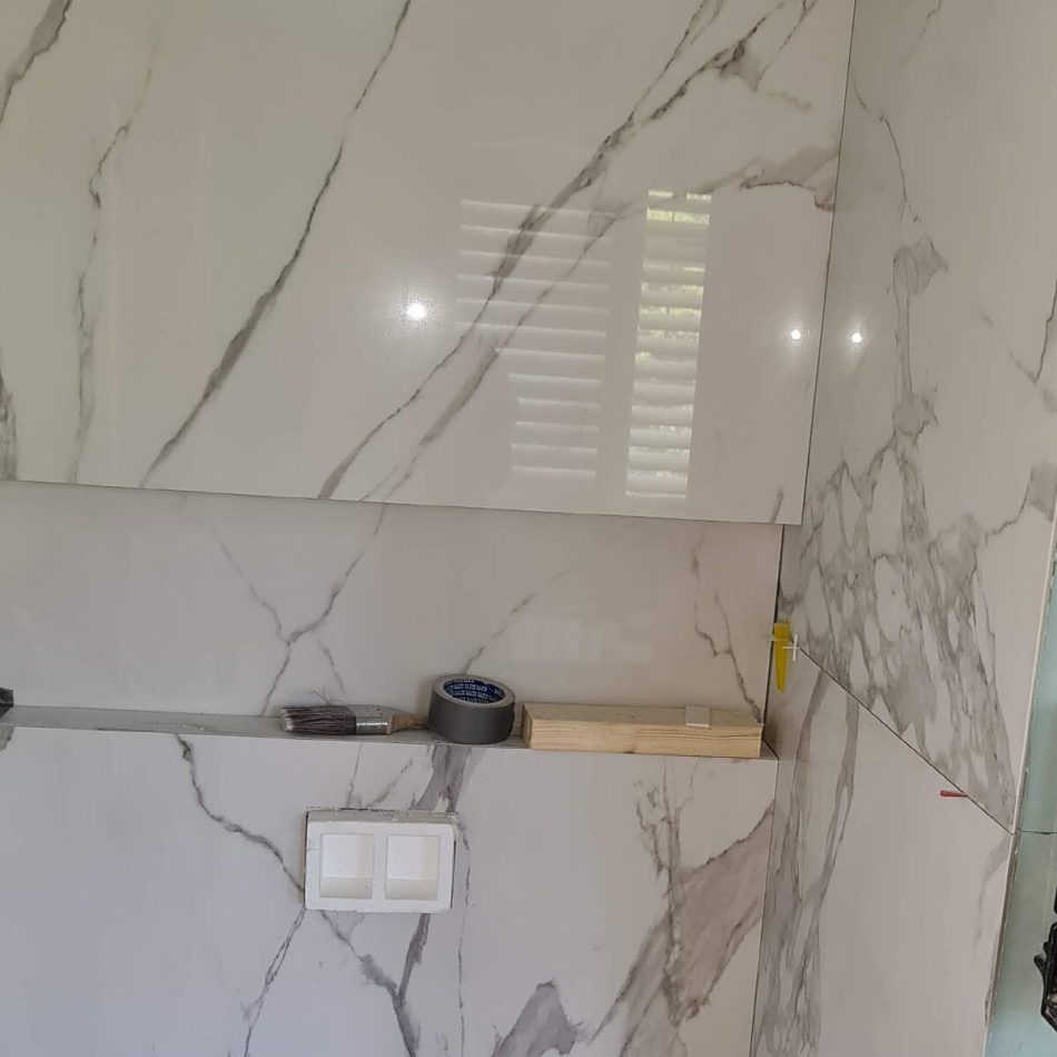 Large-format marble-effect wall tiles installed during the Weybridge bathroom refurbishment